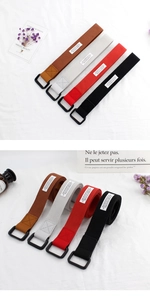 Detail of four-color canvas belts with black metal D-rings and fabric label tags