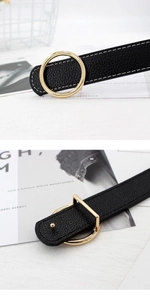 Détail d'une ceinture en cuir noir avec boucle dorée et surpiqûres blanches contrastées