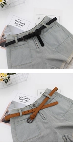 Detail of slim black and brown faux leather belts styled on high-waist denim shorts
