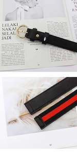 Détail de la ceinture montrant la boucle dorée et la sangle rayée rouge et verte chic
