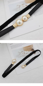 Détail de la ceinture élastique noire élégante avec deux perles blanches sur boucle dorée