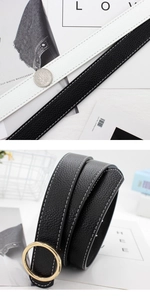 Détail d'une ceinture en cuir à motif litchi avec coutures blanches et boucle dorée