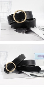 Détail d'une ceinture en cuir noir avec surpiqûres blanches et boucle ronde dorée