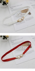 Détail de la ceinture élastique avec une élégante boucle à deux perles pour robes de femmes