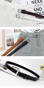 Detail of slim leather belts with contrast stitching and silver buckles on jeans