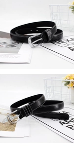 Close-up of black leather thin belt with white contrast stitching and silver buckle