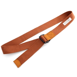 Caramel canvas belt with black double D-ring metal buckle and woven label on white background