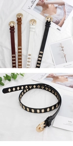 Close-up of stylish faux leather belts with gold metal buckles and oval eyelet details