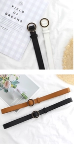 Detailed flat lay of women thin leather belts in black white and brown with round buckles