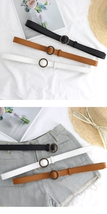 Three minimalist women's leather belts in black, brown and white with round metal buckles
