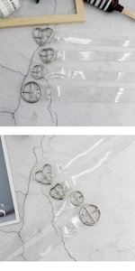 Vista dettagliata di cinture in PVC trasparente con fibbie in metallo a cuore e tonde