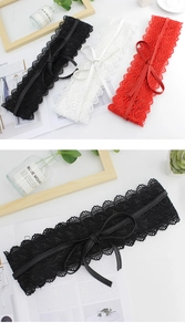 Macro shot of wide floral lace belts with slim leather bows in black, white, and red colors