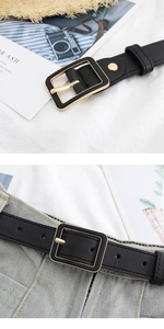 Close-up of black PU leather belt with square metal buckle on denim jeans lifestyle view