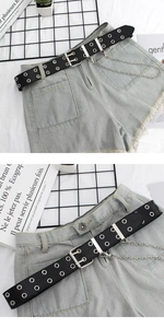 Détail d'une ceinture punk en cuir noir avec œillets doubles et chaîne en métal amovible