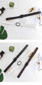Détail de fines ceintures en cuir noir blanc et marron avec boucles ovales mates et coutures