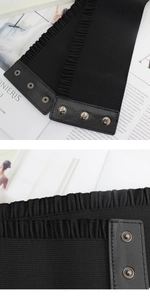 Detail of wide black elastic waist belt with three metal buttons and ruffle trim
