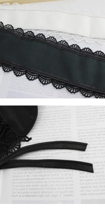 Detail of elegant black and white lace waist cinchers with decorative scalloped edges