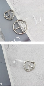 Dettagli delle fibbie metalliche a cuore e tonde su cinture in PVC trasparente