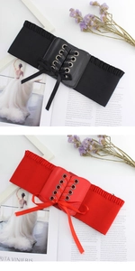 Detail of wide elastic corset belt with ribbon lace-up and metallic eyelets on magazine