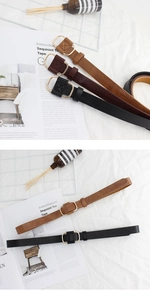 Detail of minimalist women's belts in black and brown with golden D-shaped buckles