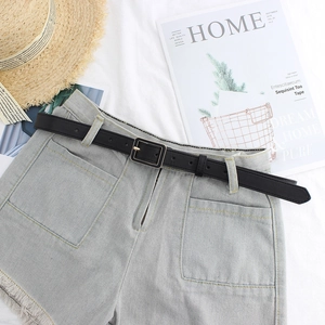 Minimalist black PU leather belt with square gold buckle on denim shorts for women