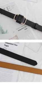 Close-up of black and brown thin leather belts with gold oval buckles on magazines