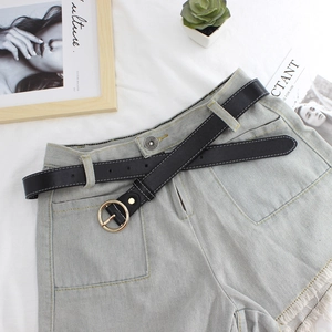 Classic black skinny leather belt for women with gold round buckle on denim shorts