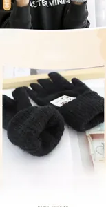 Dettaglio di guanti in maglia spessa con tessuto morbido e toppa con lettera alla moda