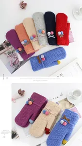 Detailed view of colorful knit mittens featuring pom-poms, bows, and diamond patterns