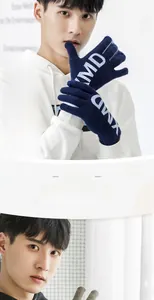Detail of dark blue knitted touchscreen gloves featuring white KMD lettering on soft cotton