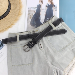 Cintura in pelle nera con doppie cuciture bianche e fibbia rotonda su pantaloncini jeans