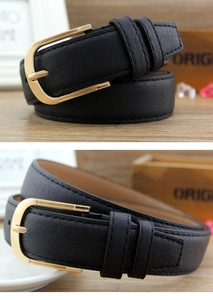 Detail view of black PU leather belt with lychee texture and golden round pin buckle