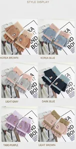 Détail de gants en tricot avec broderie de dessin animé et fermeture à bouton en bois
