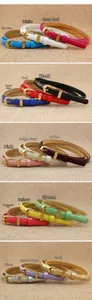 Detail of colorful women's skinny belts with ornate golden buckles and glossy finish