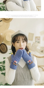 Detail of blue knit gloves with thick fleece lining, pom-poms and warm contrast fingertips