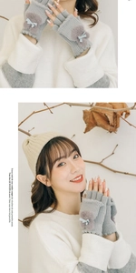 Close-up of grey knitted fingerless gloves with plush pom pom and light blue bow detail