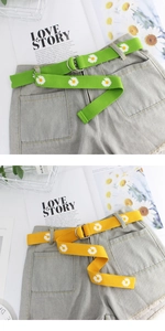 Close-up of canvas belts with white daisy prints and silver double D-ring buckles