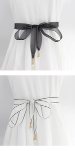 Detail view of thin gauze waist rope belts with pearl pendants and gold metal ball accents
