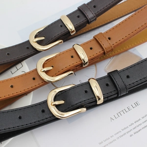 Ceintures fines chic pour femmes en noir et marron avec boucles dorées sur des magazines