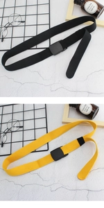 Détail de ceintures en toile noires et jaunes avec boucles en plastique sur fond texturé