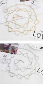 Dettaglio della cintura a maglie metalliche a forma di cuore in oro e argento