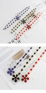 Dettaglio della catena in perle con ciondoli floreali in cristallo rosso, nero e blu