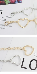 Vista macro dettagliata di ciondoli a forma di cuore in oro e argento con chiusura a moschettone