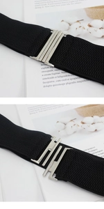 Detail view of the silver metal interlocking buckle on black elastic waist belt