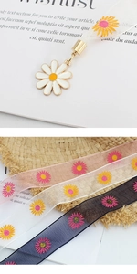 Détail du pendentif marguerite et rubans en organza à motifs floraux colorés variés