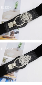Detail of black elastic waist belts with crocodile texture and rhinestone flower buckles