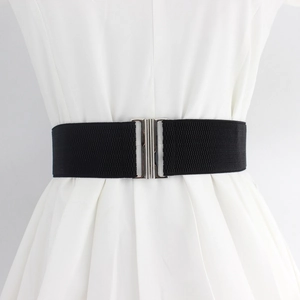 Elastic black waist belt with silver metal buckle styled on white dress