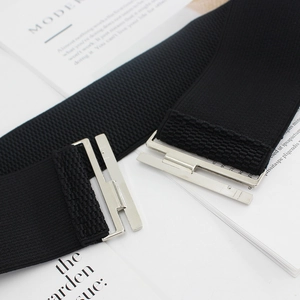 Modern black elastic wide waist belt with elegant silver metal buckle closure