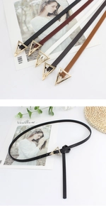 Detail view of colorful skinny belts with golden triangle buckles in various colors