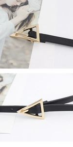 Detailed close-up of a women's black skinny belt with a gold triangular buckle